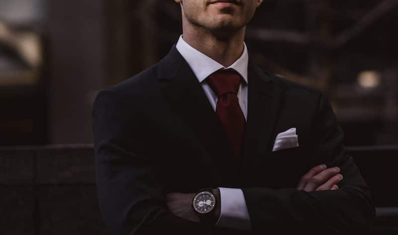 man wearing black notched lapel suit jacket in focus photography